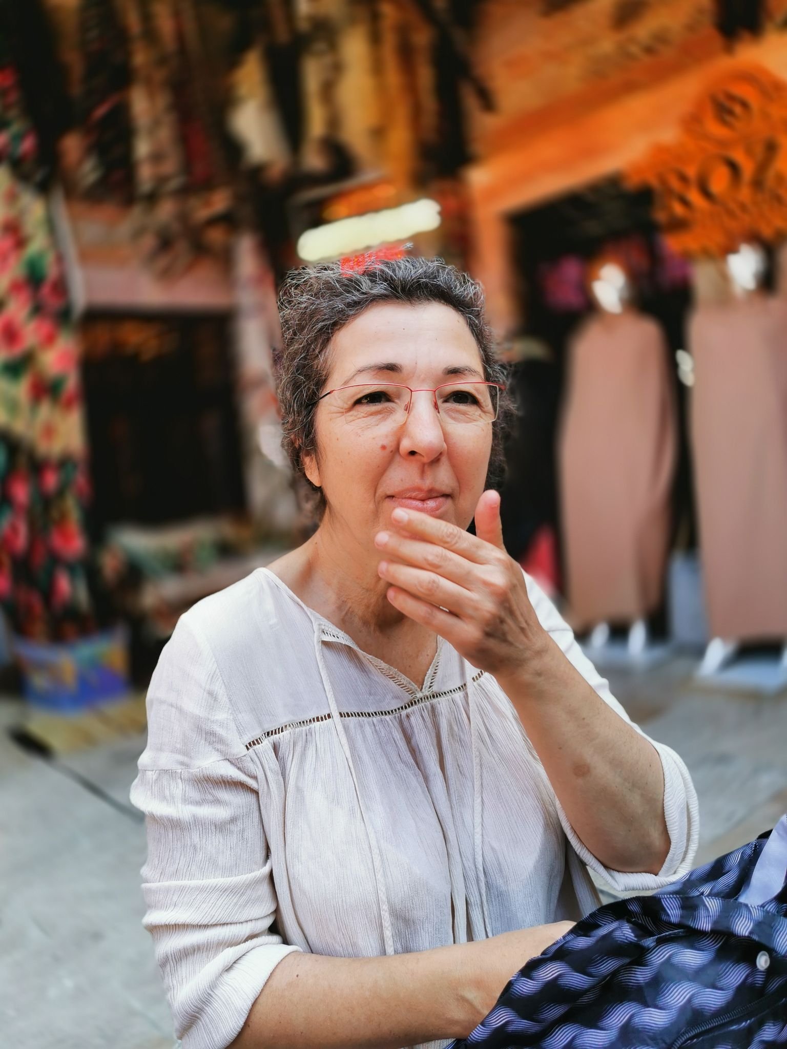 A candid shot of a woman at a vibrant outdoor market in İzmir, Türkiye.