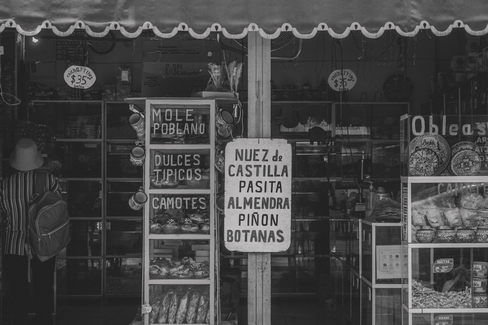 Black and white image of a traditional grocery store entrance in Puebla, Mexico, showcasing local snacks.