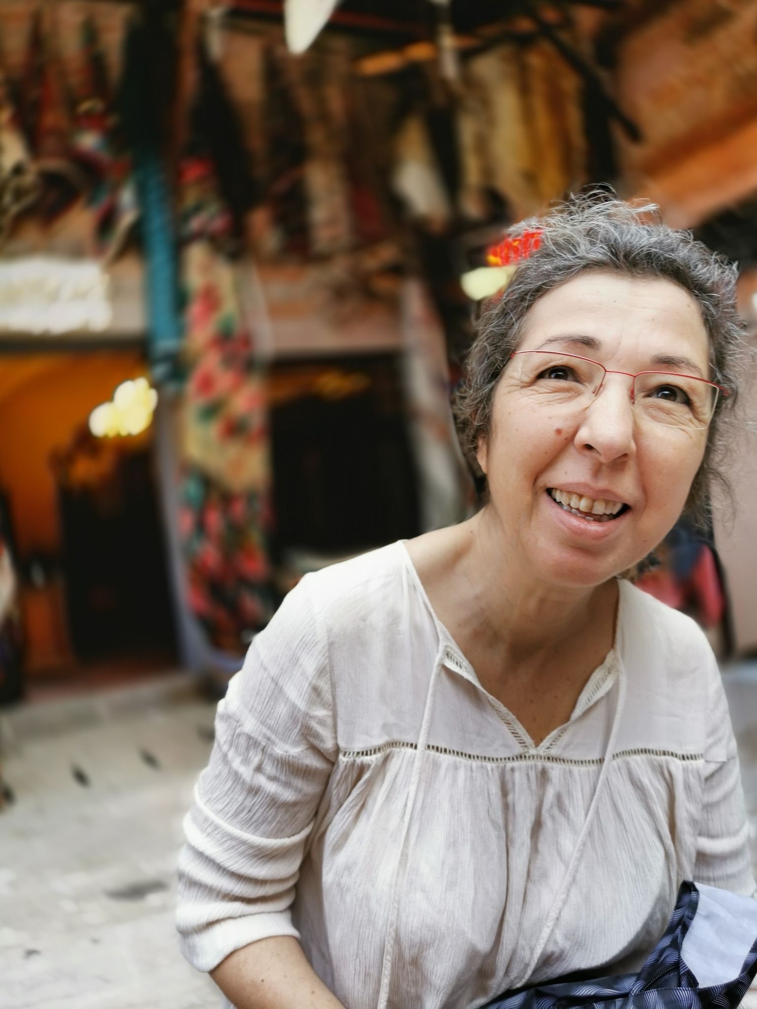 Portrait of a joyful woman in a vibrant bazaar setting in İzmir, Türkiye.